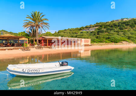 Corse, FRANCE - JUN 23, 2015 : Canot voile s'ancrant dans petite baie avec plage et restaurant aux beaux jours d'été. Cette île française est populaire Banque D'Images