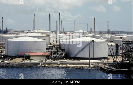 Réservoirs de stockage et de fumeurs de cheminées d'une grande raffinerie de pétrole brut jusqu'à la côte de Curaçao, une île de la mer des Caraïbes du sud qui est un pays territoriale des Pays-Bas. Le pétrole est la principale industrie de cette enclave néerlandaise, qui est également une destination touristique populaire. Banque D'Images