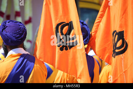Symbole de la religion Sikh appelé KHANDA constitué par deux cimeterres sur les drapeaux orange et l'homme avec le turban bleu Banque D'Images