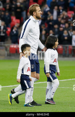 Londres, Grande-Bretagne. Apr 30, 2018. Tottenham Hotspur Harry Kane entre dans le terrain avec ballkids de Chine avant la Premier League match de foot entre Tottenham Hotspur et Watford au stade de Wembley à Londres, Grande-Bretagne, le 30 avril 2018. Tottenham Hotspur a gagné 2-0. Crédit : Tim Irlande/Xinhua/Alamy Live News Banque D'Images