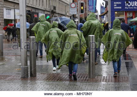 Un jour de pluie à Dublin les gens traversent la rue O'Connell. Banque D'Images