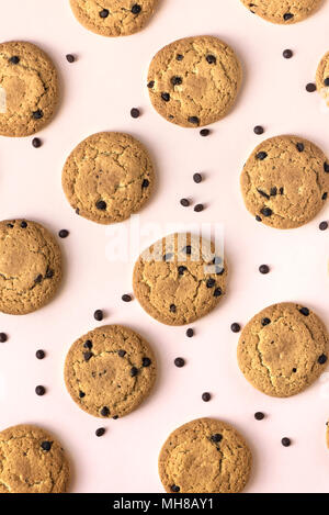 Cookies aux pépites de chocolat sur rose pastel arrière-plan, Vue de dessus. Banque D'Images