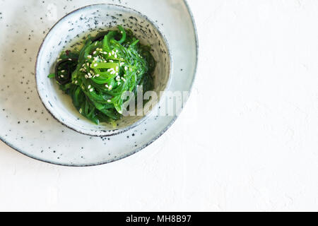 Salade d'Algues Chuka dans un bol en céramique sur fond blanc, copie de l'espace. Cuisine japonaise - Salade Chuka Banque D'Images