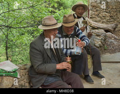 Les Tibétains locaux avec des roues de prière et le vin de riz dans le village de Jiaju, Sichuan, Chine Banque D'Images