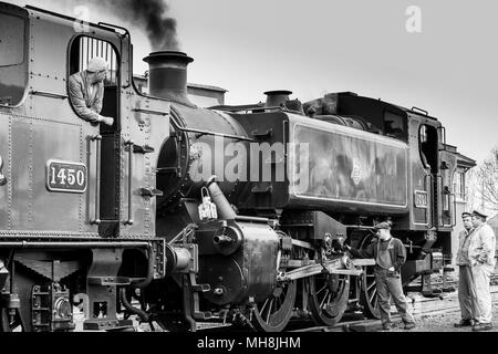 Gros plan noir et blanc, deux locomotives à vapeur britanniques anciennes, ainsi que l'équipage, ligne du patrimoine ferroviaire de Severn Valley en attente de départ, double cap. Banque D'Images