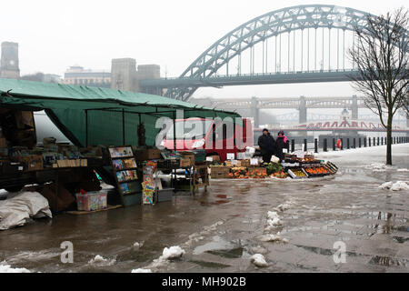 Les commerçants du marché vend des fruits et légumes sur un quai abandonné sur un dimanche matin enneigé à Newcastle, Tyne et Wear, Angleterre. Banque D'Images