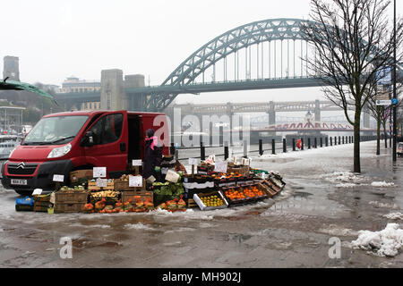 Les commerçants du marché vend des fruits et légumes sur un quai abandonné sur un dimanche matin enneigé à Newcastle, Tyne et Wear, Angleterre. Banque D'Images