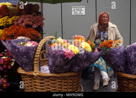 Vendeur de fleurs sur le coin de rue Belgrave Square et Belgrave place London SW1. Femme âgée plus âgée oap travaille toujours à la vente de fleurs UK Angleterre 1980s 1982. HOMER SYKES Banque D'Images