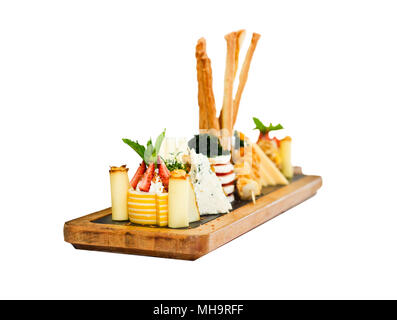 Plateau de fromages : le roquefort avec moisissure bleue, cheddar, fromage fumé, mozzarella sur une planche de bois. Décorées avec la groseille, la fraise et petits fruits Banque D'Images