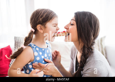 Jeune maman avec une petite fille à la maison, de manger. Banque D'Images