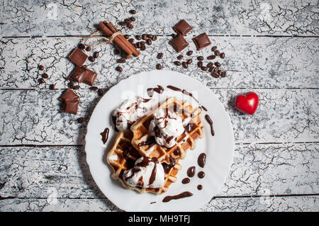 Gaufre belge avec la crème glacée, chocolat, café sur un fond de bois. Jour de la Saint-Valentin. Banque D'Images