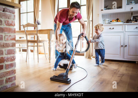 Son père et ses deux jeunes enfants à faire des travaux ménagers. Banque D'Images