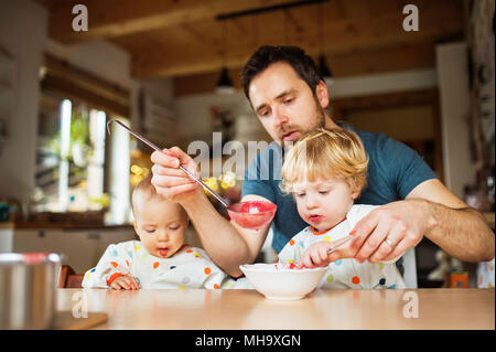 Père de deux jeunes enfants d'alimentation à la maison. Banque D'Images