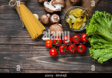 Les pâtes, tomates, salade, poivrons, champignons et livre de recettes sur fond de table en bois. Banque D'Images