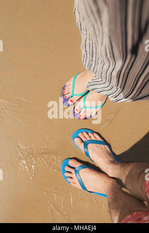 Couple de selfies pieds en sandales chaussures sur fond de sable de plage Banque D'Images