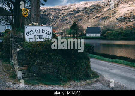 30 avril 2018, Gougane Barra, comté de Cork, Irlande - Gougane Barra Hotel sign avec la chapelle de l'Oratoire Saint Finbarr et au lac de la backgroun Banque D'Images