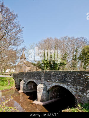 Le pont sur la rivière Dore à Vowchurch dans le Herefordshire montrant l'église de St Barthélemy situé entre les arbres. Banque D'Images