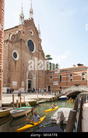 Trois kayakistes pagayant passé Basilica di Santa Maria Gloriosa dei Frari sur le Rio dei Frari, San Polo, Venise, Vénétie, Italie vacances de détente activit Banque D'Images