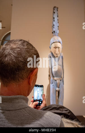 le touriste arrachant une statue d'art primitif en bois avec son téléphone mobile, musée du louvre, paris, france Banque D'Images