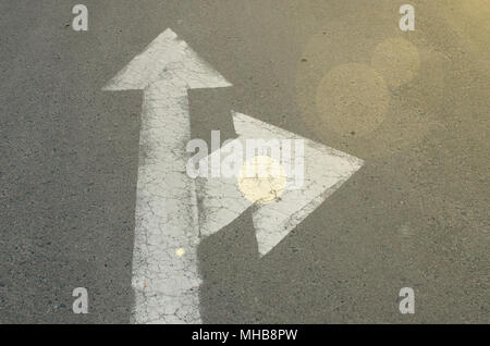 Flèche blanche sur la route. La signalisation horizontale. L'avant et à droite sur la route de signes Banque D'Images
