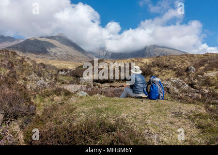 Femme assise à la Walker vers Coire Lagan dans les montagnes Cuillin noires, Isle of Skye, Scotland, UK Banque D'Images