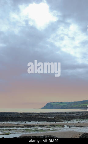 Seascape de Robin Hood's Bay vu en milieu de matinée sous un ciel nuageux Banque D'Images