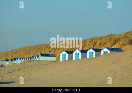 Peu de cabines de plage au coucher du soleil sur la mer du Nord sur waddeneiland Texel Hollande Europe. Banque D'Images