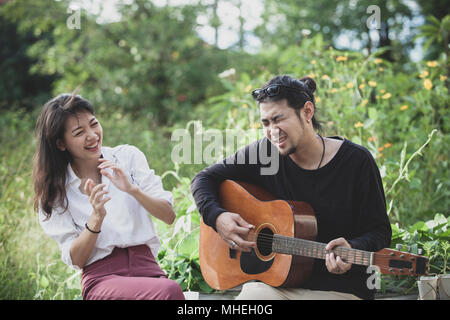 Jeune asiatique l'homme et de la femme qui joue de la guitare avec bonheur l'émotion Banque D'Images
