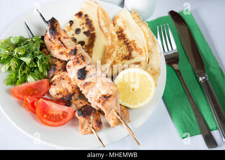 Un bain turc traditionnel plat de poulet shish kebab, şiş tavuk kebap, servi avec des feuilles de salade, tomates et pain plats turcs. Banque D'Images