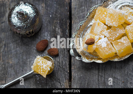 Loukoum - lokum orange, amandes et de café turc sur fond de bois Banque D'Images