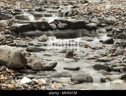 Flux avec l'eau qui coule sur les rochers et les pierres Banque D'Images