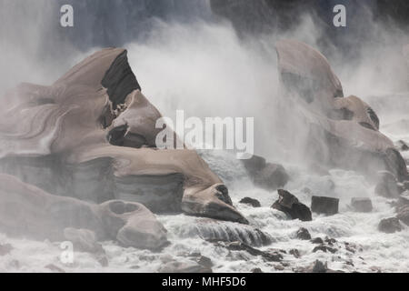 La photographie de paysage en couleur illustrant l'eau de l'American Falls de Niagara Falls, États-Unis d'Amérique et la formation de glace et de neige sur les rochers au-dessous. Banque D'Images