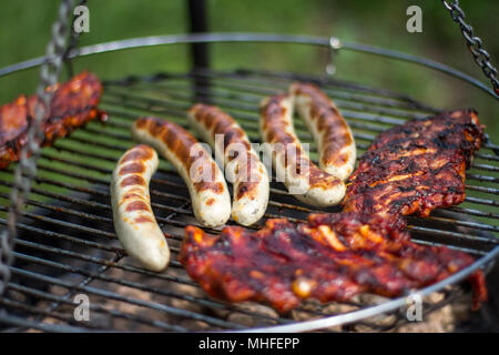 Griller des saucisses et des spareribs sur le gril Banque D'Images