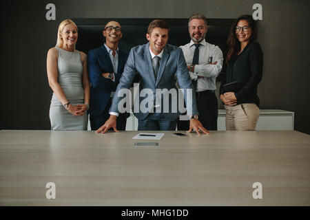 Sympathique équipe de professionnels des affaires dans la salle de réunion. Groupe d'entreprises à la caméra et au sourire dans la salle de conférence. Banque D'Images