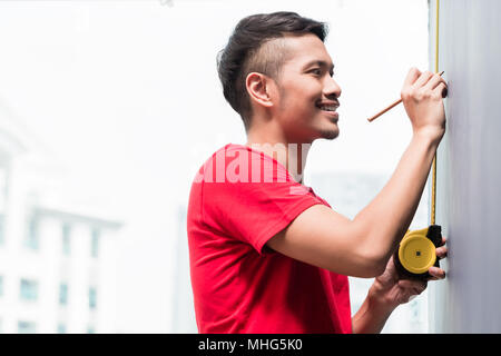 Young indonesian man sizing avec ruban de mesure Banque D'Images