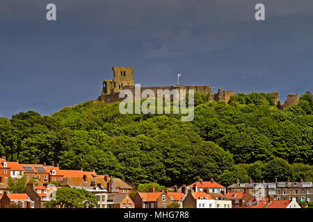 Le Château de Scarborough et remparts s'asseoir au-dessus de la vieille ville contre un ciel orageux. Banque D'Images