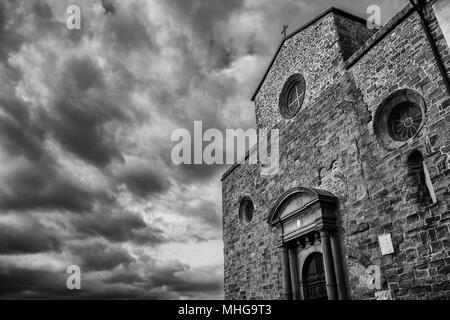 Belle cathédrale médiévale de Cortona en Toscane avec ciel nuageux (dramatique en noir et blanc avec copie espace) Banque D'Images