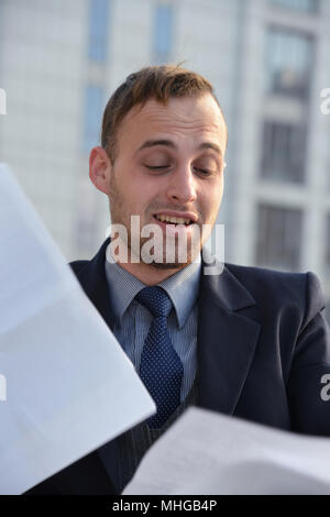 Businessman émotionnellement la lecture de documents Banque D'Images