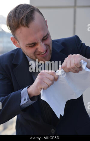 Businessman émotionnellement normale et manger les documents papier Banque D'Images