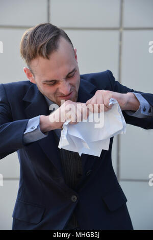 Businessman émotionnellement normale et manger les documents papier Banque D'Images