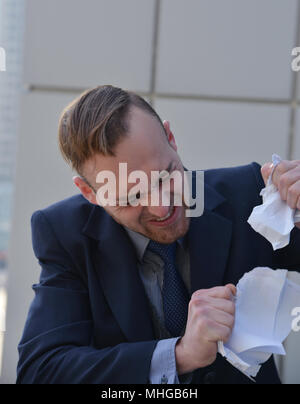 Businessman émotionnellement normale et manger les documents papier Banque D'Images