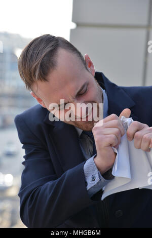 Businessman émotionnellement normale et manger les documents papier Banque D'Images