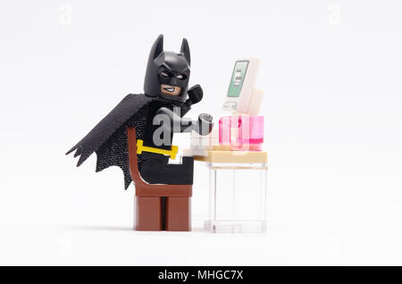 Mini figure de Batman sur chaise devant l'ordinateur. Figurines Lego sont fabriqués par le groupe Lego. Banque D'Images