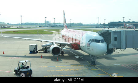 Singapour - 4 avr 2015 : Airbus A320-200 Air Asia en attente à l'embarquement à l'Aéroport International de Changi pour passagers, Air Asia Company est la plus grande des compagnies aériennes à bas prix en Asie Banque D'Images