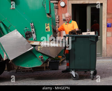 Stockholm, Suède - le 18 juin 2013 : un homme en salopette orange se vide ordures dans un camion poubelle verte sur la place principale de la Vieille Ville Banque D'Images