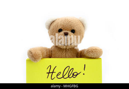 Ours en peluche brun tenant avec les deux mains une note en couleur jaune vif avec le message manuscrit "Bonjour !". Photo isolées dans un blanc transparent ba Banque D'Images
