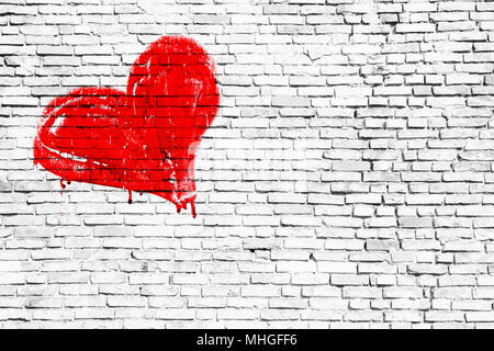 Coeur de couleur rouge peint manuellement avec les gouttes et les imperfections de la peinture sèche sur un simple mur de brique blanc grunge texture background. Symbolique pour l'amour, Banque D'Images