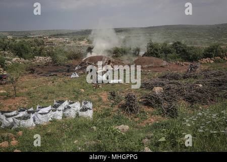 Dpatop - syriens portent un sac de charbon, fabriqué à partir de bois de chêne, dans le gouvernorat de Kafr Kila, Idlib, Syrie, 28 avril 2018. Les gens de Kafr Kila, une ville principalement habitée par les caractère ethnoreligieux groupe des druzes, a été la pratique de l'agriculture et de la fabrication du charbon pour des dizaines d'années. Photo : afp/ALkharboutli Anas Banque D'Images