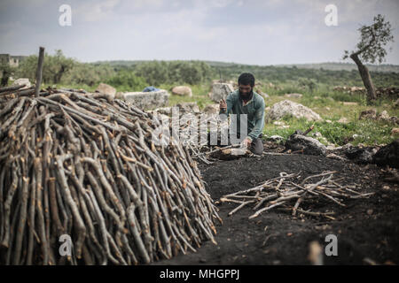 Dpatop - un homme syrien sortes bois de chêne pour la fabrication du charbon dans le gouvernorat de Kafr Kila, Idlib, Syrie, 28 avril 2018. Les gens de Kafr Kila, une ville principalement habitée par les caractère ethnoreligieux groupe des druzes, a été la pratique de l'agriculture et de la fabrication du charbon pour des dizaines d'années. Photo : afp/ALkharboutli Anas Banque D'Images