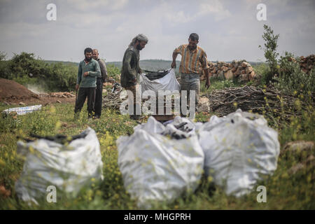 Dpatop - syriens transporter des sacs de charbon, fabriqué à partir de bois de chêne, dans le gouvernorat de Kafr Kila, Idlib, Syrie, 28 avril 2018. Les gens de Kafr Kila, une ville principalement habitée par les caractère ethnoreligieux groupe des druzes, a été la pratique de l'agriculture et de la fabrication du charbon pour des dizaines d'années. Photo : afp/ALkharboutli Anas Banque D'Images